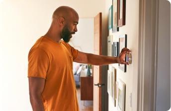 Man adjusting thermostat